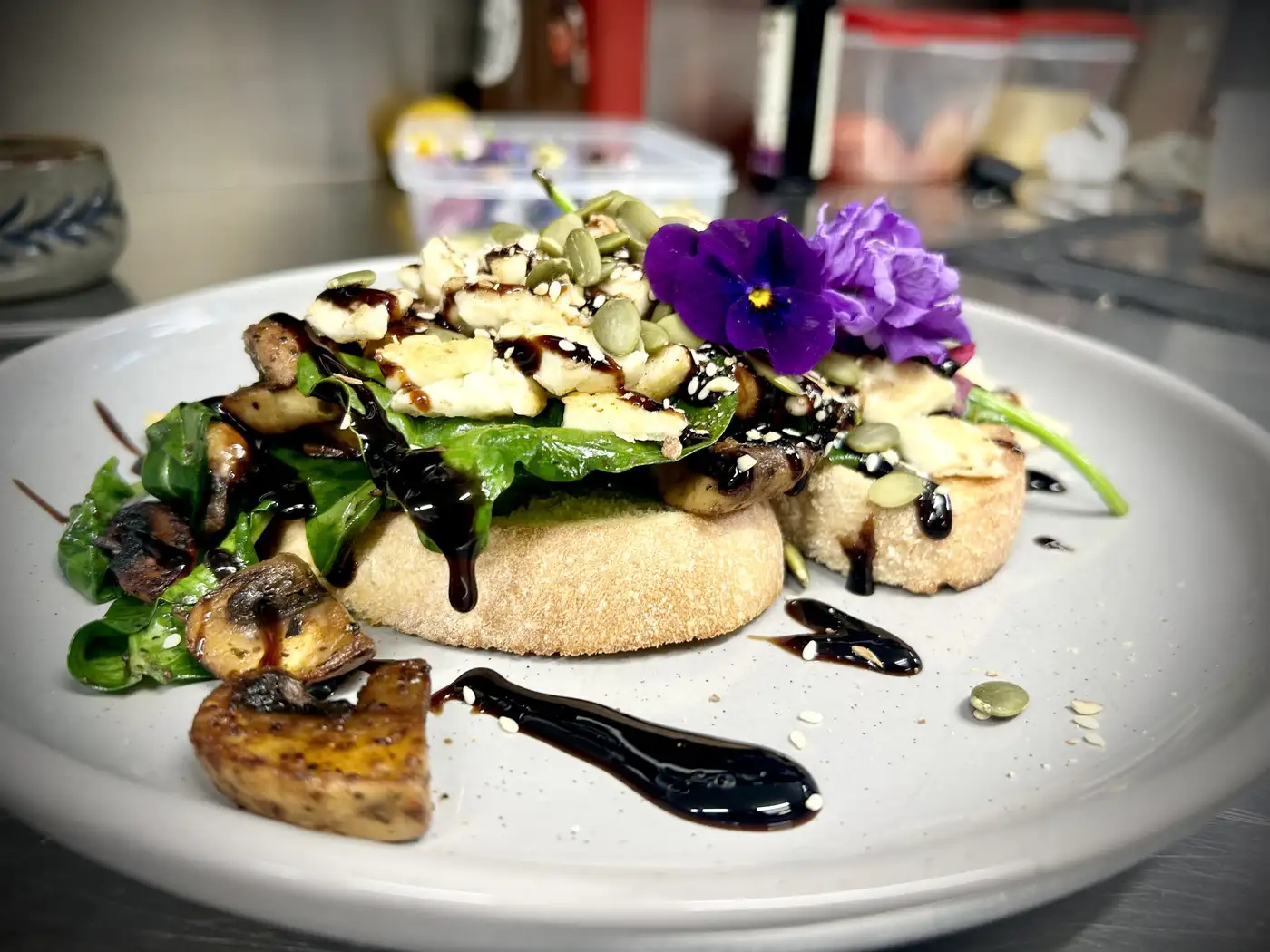 Handcrafted mushroom halloumi ciabatta with balsamic glaze and edible flowers
