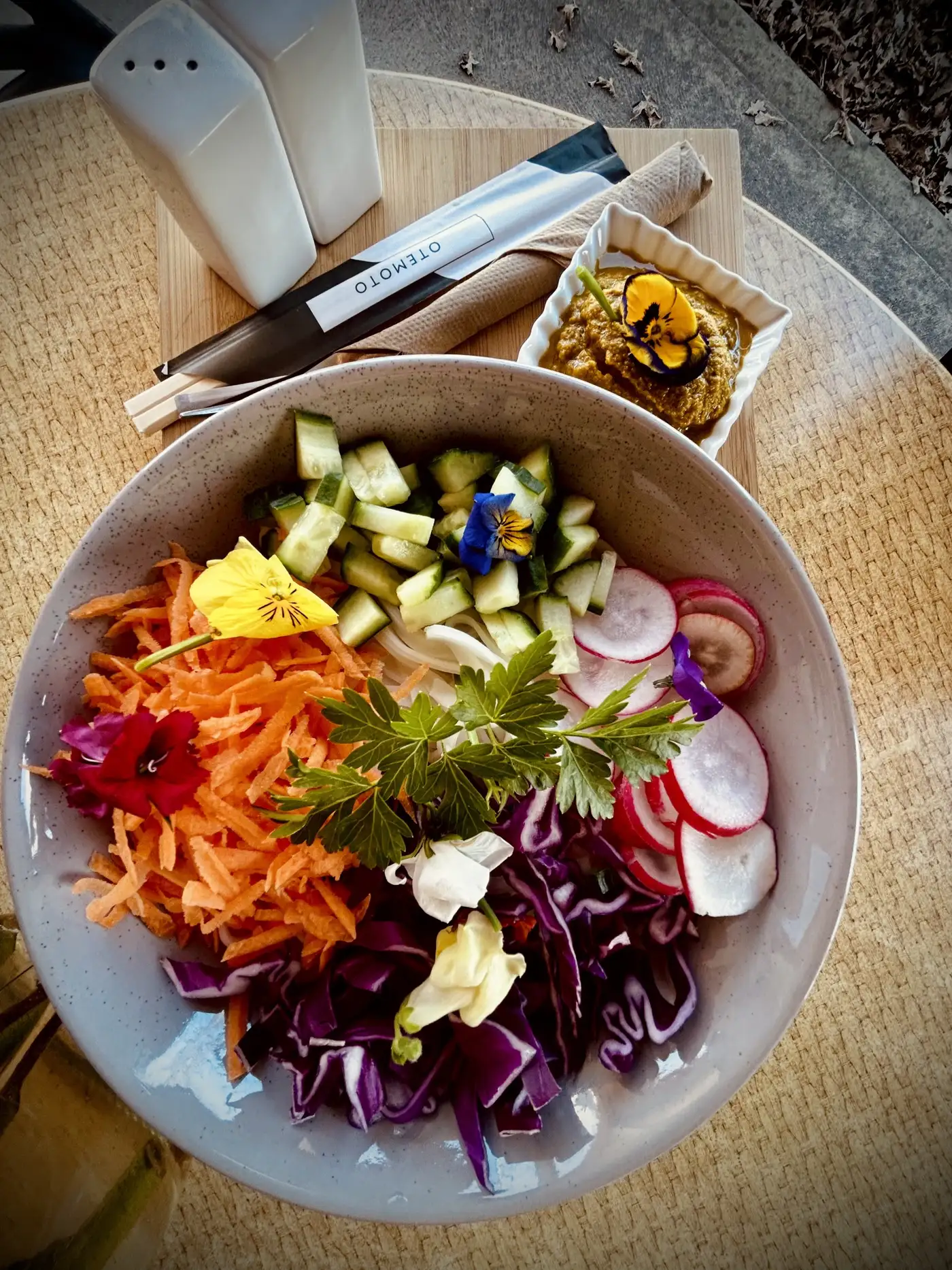 Rainbow salad bowl with edible flowers, purple cabbage, carrot and radish